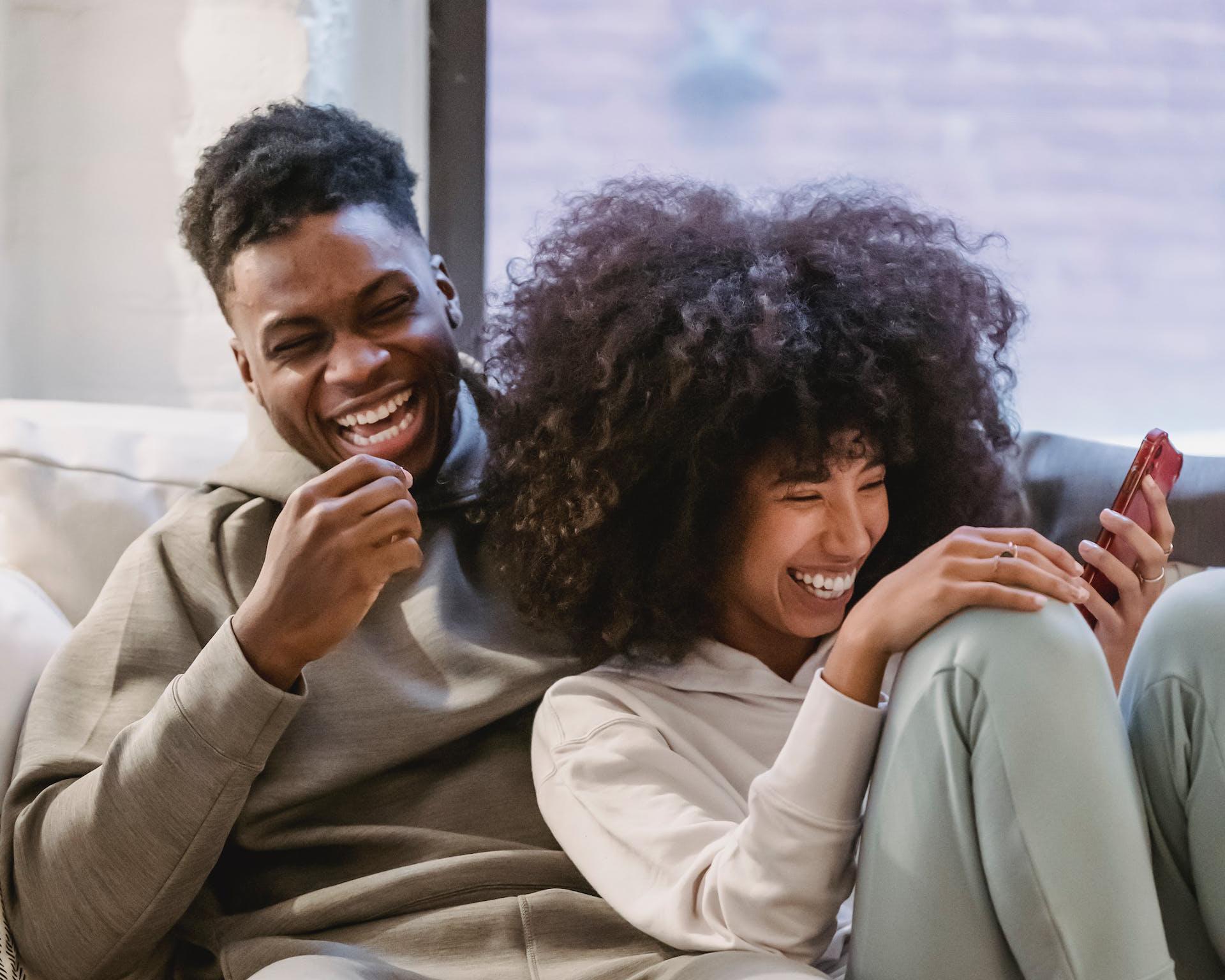 Man and woman happily looking at a laptop together